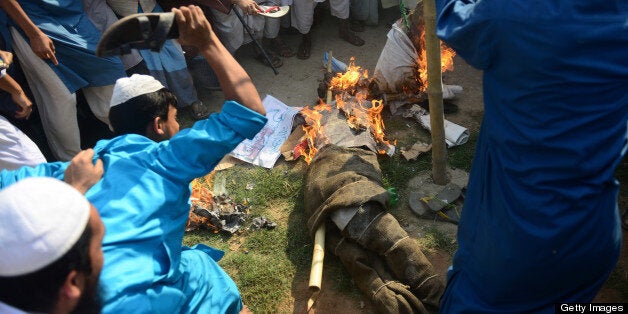 Supporters of Islamic political parties burn and kick an effigy of a blogger inside a madrasa during a nationwide strike in Dhaka on February 24, 2013. The Islamist parties called for a nationwide dawn-to-dusk shutdown on Sunday protesting attacks on demonstrators who were demanding punishment against the 'atheist' bloggers of the Shahbagh movement. AFP PHOTO/Munir uz ZAMAN (Photo credit should read MUNIR UZ ZAMAN/AFP/Getty Images)