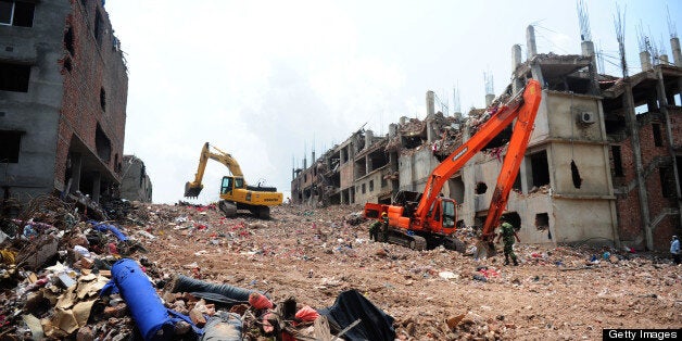Excavators clear debris as Bangladeshi rescue and army personnel continue recovery operations at the site of the eight-storey