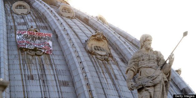 Italian businessman Marcello De Finizio stands on the dome of St Peter's basilica to protest against austerity measures on May 20, 2013 at the Vatican. The businessman hung a banner saying: ' Stop this massacre, the political horror show is continue....help us Pope Francis... '. AFP PHOTO / FILIPPO MONTEFORTE (Photo credit should read FILIPPO MONTEFORTE/AFP/Getty Images)