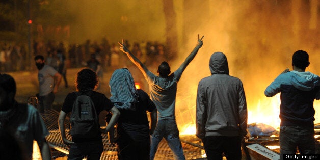 Protestors clash with riot police near the Taksim Gezi park in Istanbul, on June 1, 2013, during a demonstration against the demolition of the park. Turkish police on June 1 began pulling out of Istanbul's iconic Taksim Square, after a second day of violent clashes between protesters and police over a controversial development project. Thousands of demonstrators flooded the site as police lifted the barricades around the park and began withdrawing from the square. What started as an outcry against a local development project has snowballed into widespread anger against what critics say is the government's increasingly conservative and authoritarian agenda. AFP PHOTO/BULENT KILIC (Photo credit should read BULENT KILIC/AFP/Getty Images)