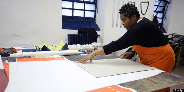 TO GO WITH STORY BY DARIO THUBURN Nigerian detainee Kalu Uwaezuoke Chinedum Ike works on handbags on May 22, 2013, inside a workshop of the Rebibbia prison in Rome. Women's prison workshops across Italy are joining up under a new commercial fashion brand they hope will help encourage more detainees to learn the trade and give them hope for a future on the outside. AFP PHOTO / ANDREAS SOLARO (Photo credit should read ANDREAS SOLARO/AFP/Getty Images)