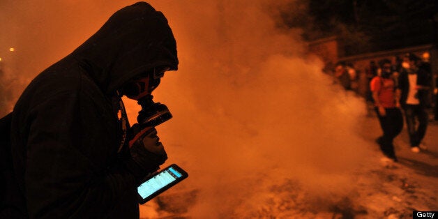 A protestor uses Facebook on mobile phone to give latestt news about the clashes near Taksim in Istanbul on June 3, 2013 during a demonstration against the demolition of the park. Turkish police on June 1 began pulling out of Istanbul's iconic Taksim Square, after a second day of violent clashes between protesters and police over a controversial development project. Thousands of demonstrators flooded the site as police lifted the barricades around the park and began withdrawing from the square. What started as an outcry against a local development project has snowballed into widespread anger against what critics say is the government's increasingly conservative and authoritarian agenda. AFP PHOTO / OZAN KOSE (Photo credit should read OZAN KOSE/AFP/Getty Images)