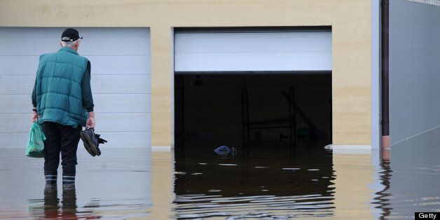 A man stands in front of his house which is flooded by the water of the Danube river in Fischerdorf near Deggendorf, southern Germany, on June 11, 2013. AFP PHOTO / CHRISTOF STACHE (Photo credit should read CHRISTOF STACHE/AFP/Getty Images)