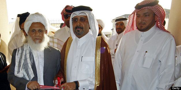 Qatari Assistant Minister for Foreign Affairs Ali bin Fahd al-Hajri (C) cuts the ribbon alongside a member of the Taliban's office Jan Mohammad Madani (L) at the opening ceremony of the new Taliban political office in Doha on June 18, 2013. The office is intended to open dialogue with the international community and Afghan groups for a 'peaceful solution' in Afghanistan Naim told reporters. AFP PHOTO / FAISAL AL-TIMIMI (Photo credit should read FAISAL AL-TIMIMI/AFP/Getty Images)