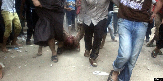 The body of a bloodied Shiite Muslim man is dragged along a street in the village of Abu Mussalam after he and others were attacked by a mob when they allegedly refused to leave a house where they had gathered, on June 23, 2013. Four Egyptian Shiite Muslims were killed and several others wounded when they were attacked by a hostile mob in the village in Giza province near the capital, police said. AFP PHOTO/STR (Photo credit should read -/AFP/Getty Images)