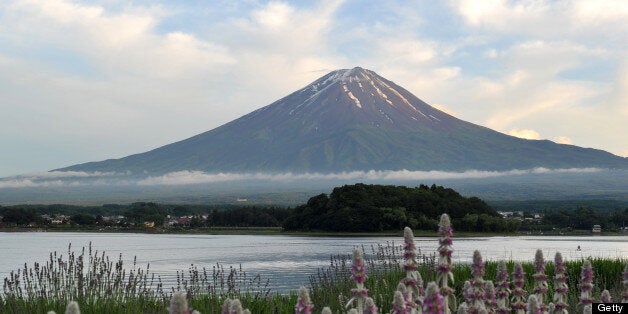 This picture taken on June 16, 2013 shows Mount Fuji, the highest mountain in Japan at 3,776 metres (12,460 feet), and Lake Kawaguchi in Fujikawaguchiko, southern Yamanashi prefecture. The UNESCO World Heritage Committee opened its annual session in Phnom Penh on June 16 to decide global cultural and natural treasures merit World Heritage status, including Japan's iconic Mt. Fuji. AFP PHOTO / KAZUHIRO NOGI (Photo credit should read KAZUHIRO NOGI/AFP/Getty Images)