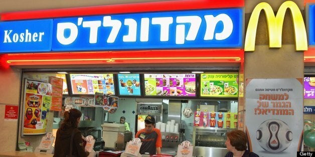 TEL AVIV, ISRAEL - MARCH 2: Israelis eat at a kosher McDonald's restaurant March 2, 2006 in Tel Aviv. This is the first time for the international corporation to give the golden arches a new background, replacing the trademark red one. The new signs also display the word 'kosher' in both Hebrew and English. (Photo by David Silverman/Getty Images)