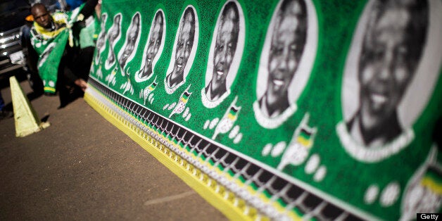 Street vendors display a large traditional fabric with portraits of South African President Nelson Mandela and ANC flags outs