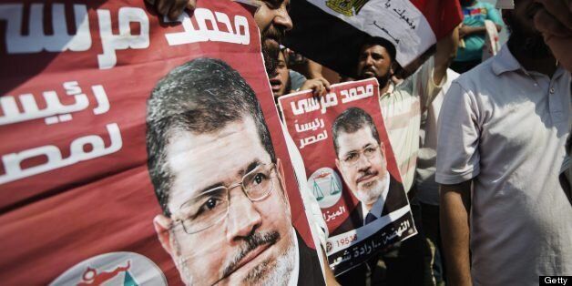 Protestors hold posters of Egyptian President Mohammed Morsi as Muslim Brotherhood members and Morsi's supporters gather outside the Rabaa El-Adaweya mosque in Cairo's eastern Nasr City district on July 2, 2013. Egypt's political crisis deepened as Islamist President Mohamed Morsi snubbed an army ultimatum threatening to intervene if he did not meet the demands of the people, and five ministers led a spate of government resignations. AFP PHOTO/GIANLUIGI GUERCIA (Photo credit should read GIANLUIGI GUERCIA/AFP/Getty Images)