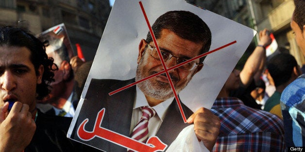 CAIRO, EGYPT - JULY 03: An anti-President Mohammed Morsi poster is viewed as as thousands of Egyptian protesters celebrate in Tahrir Square as the deadline given by the military to Egyptian President Mohammed Morsi passes on July 3, 2013 in Cairo, Egypt. The president gave a defiant speech last night and vowed to stay in power despite the military threats. As unrest spreads throughout the country, at least 23 people were killed in Cairo on Tuesday and over 200 others were injured. It has been reported that the military has taken over the state television. (Photo by Spencer Platt/Getty Images)