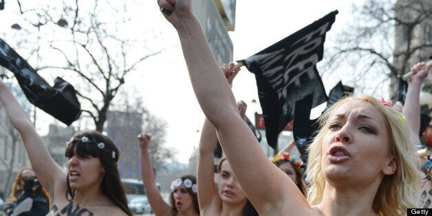 Ukrainian activist Inna Shevchenko (C) of the women's rights movement Femen takes part in a topless protest with other Femen activists near Tunisia's Embassy in Paris on April 4, 2013. Femen called for a day of international 'topless jihad' on April 4 with Femen groups staging protests in various European cities in support of Amina, a young Tunisian woman who caused a scandal when she published photos of herself bare-chested on the internet in March. AFP PHOTO / MIGUEL MEDINA (Photo credit should read MIGUEL MEDINA/AFP/Getty Images)