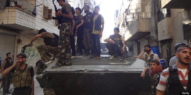 Syrian rebel fighters gather around a former Syrian army tank as rebels prepare to attack positions held by the Syrian army areas in the Salaheddine neighborhood of Aleppo, on July 8, 2013. Syria's rebel prime minister Ghassan Hitto announced his resignation, nearly four months after his appointment and having failed to form a government. AFP PHOTO/ABO MHIO (Photo credit should read ABO MHIO/AFP/Getty Images)