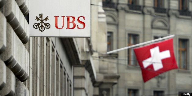 A Swiss flag is seen behind a sign of Swiss bank giant UBS on June 11, 2013 in Basel. AFP PHOTO / FABRICE COFFRINI (Photo credit should read FABRICE COFFRINI/AFP/Getty Images)