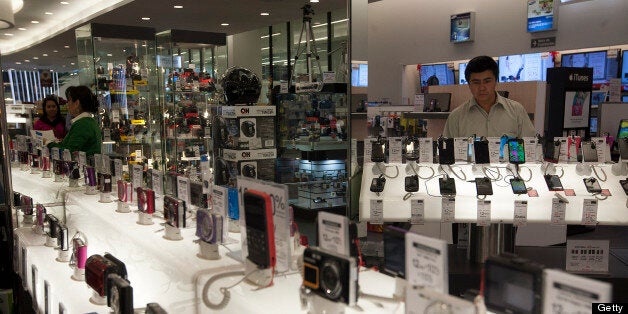 A customer looks at Apple Inc. iPhones at a Grupo Sanborns SAB store in the Plaza Carso development in Mexico City, Mexico, on Friday, Feb. 8, 2013. Grupo Sanborns SAB, the retailer controlled by Mexican billionaire Carlos Slim, raised 10.5 billion pesos ($825 million) in an initial public offering (IPO) last week and the total could climb to 12.1 billion pesos including an overallotment option for underwriters. Photographer: Susana Gonzalez/Bloomberg via Getty Images