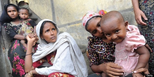 A Muslim Rohingya family sits outside their temporary relief camp in a school in Thetkaepyin village on the outskirts of Sittwe on May 17, 2013. Bangladesh and Myanmar cleaned up after a killer cyclone wrecked thousands of homes, relieved that the damage was not much worse after the storm weakened as it made landfall. AFP PHOTO / Soe Than WIN (Photo credit should read Soe Than WIN/AFP/Getty Images)