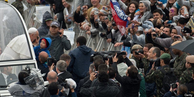 Pope Francis kisses a child upon his arrival on the popemobile at the Basilica of Our Lady of Aparecida, Brazil's most revered Catholic shrine, in Aparecida, Sao Paulo State, on July 24, 2013. The first Latin American and Jesuit pontiff is in Aparecida to lead his first big mass since arriving in the country for a week-long visit of which highlight is the huge five-day Catholic gathering World Youth Day. AFP PHOTO / CHRISTOPHE SIMON (Photo credit should read CHRISTOPHE SIMON/AFP/Getty Images)