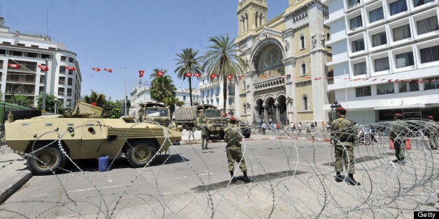 Tunisian soldiers stand guard on the fringes of an anti-government demonstration on the Habib Bourguiba Avenue on July 26, 20