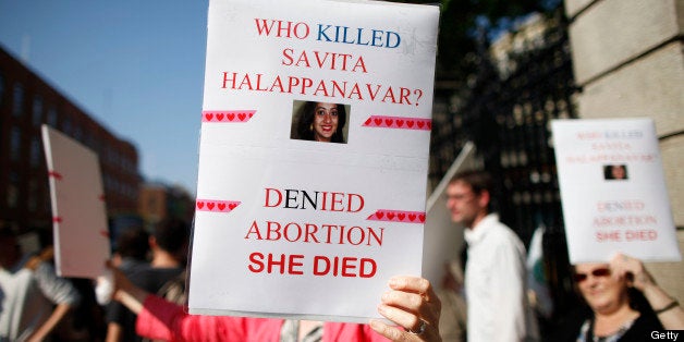 A pro-abortion supporter holds up a placard in front of the gates of the Irish Parliament building in Dublin on July 10, 2013 during a demonstration ahead of a vote to introduce abortion in limited cases where the mother's life is at risk. The bill follows a 2010 European Court of Human Rights ruling that found Ireland failed to implement properly the constitutional right to abortion where a woman's life is at risk. AFP PHOTO / PETER MUHLY (Photo credit should read PETER MUHLY/AFP/Getty Images)