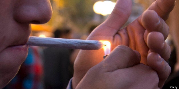 A young man lights a marijuana cigarette during a demonstration demanding a new law on cannabis in Montevideo on May 8, 2013.