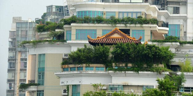 A temple is seen on the rooftop of a 21-storey apartment building in Shenzhen, south China's Guangdong province on August 21, 2013. The latest rooftop architectural wonder highlighted in China is a temple that brings worshippers closer to the heavens by being on top of a 21-storey apartment block. Surrounded by foliage, the temple has glazed golden tiles and traditional upturned eaves with carvings of dragons and phoenixes, but defies convention by standing on top of the tower in Shenzhen, the Yangcheng Evening News reported. CHINA OUT AFP PHOTO (Photo credit should read STR/AFP/Getty Images)