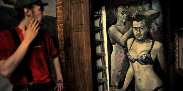 A visitor looks at an artwork representing Russia's President Vladimir Putin and Russian Prime Minister Dmitry Medvedev by Ru