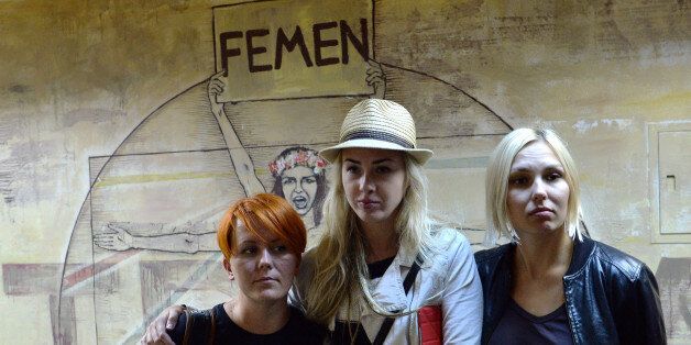 (From L) Anna Hutsol, Ukrainian feminist movement FEMEN leader, and activists Oleksandra Shevchenko and Yana Zhdanova pose for the photographer in the organisation's office in Kiev after police conducted a search on August 27, 2013. . Ukrainian police claimed on Tuesday they had found weapons in the offices of feminist movement Femen, a move the group slammed as the latest provocation by the authorities. Kiev police released a statement, saying that police had received an anonymous call saying that explosives had been planted at the premises located at 21 b, Mykhailivska Street, the address of the Feminist group in the Ukrainian capital Kiev. Bomb disposal technicians have been dispatched to the premises, the statement said without mentioning the group's name. AFP PHOTO/ SERGEI SUPINSKY (Photo credit should read SERGEI SUPINSKY/AFP/Getty Images)