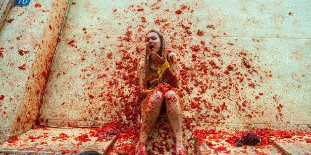 BUNOL, SPAIN - AUGUST 28: Revellers celebrate covered by tomato pulp while participating the annual Tomatina festival on August 28, 2013 in Bunol, Spain. An estimated 20,000 people threw 130 tons of ripe tomatoes in the world's biggest tomato fight held annually in this Spanish Mediterranean town. (Photo by David Ramos/Getty Images)