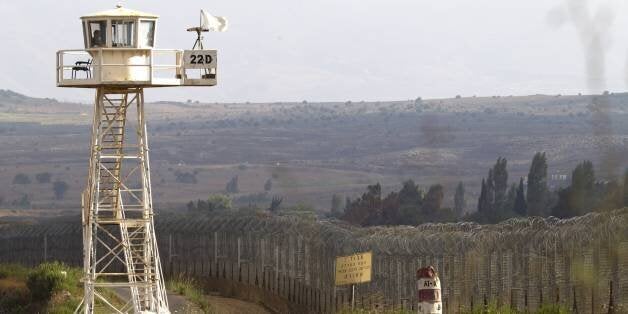 A UN peacekeeper keeps watch from an observation tower near the Quneitra crossing in the demilitarized United Nations Disenga