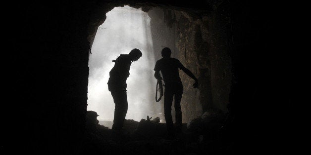 Syrian rebels take cover during clashes with regime forces at the Umayyad Mosque in the old city of Aleppo hours before the Syrian army retook control of the complex on October 14, 2012. Syria's army retook control of the historic mosque after fierce clashes with rebels in and around the area, a military official and the Syrian Observatory for Human Rights said. AFP PHOTO/Tauseef MUSTAFA (Photo credit should read TAUSEEF MUSTAFA/AFP/GettyImages)