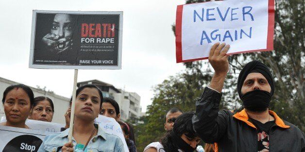 Indian protesters wear black ribbons and hold placards during a demonstration in Bangalore on December 29, 2012, after the death of a gang rape victim from the Indian capital New Delhi. Indian leaders appealed for calm and security forces headed off fresh unrest by turning New Delhi into a fortress after a student who was savagely gang-raped died in a Singapore hospital. Police threw a ring of steel around the centre of the Indian capital after news of the 23-year-old medical student's death was broken in the early hours by the Singapore hospital that had been treating her for the last two days. AFP PHOTO/ Manjunath Kiran (Photo credit should read Manjunath Kiran/AFP/Getty Images)