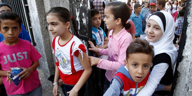 Syrian pupils arrive at a school in al-Midan district of the Syrian capital Damascus on September 15, 2013 on the first day of the new school year. AFP PHOTO ANWAR AMRO (Photo credit should read ANWAR AMRO/AFP/Getty Images)