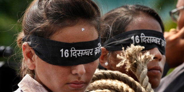 NEW DELHI, INDIA - SEPTEMBER 10: Protestors stage a mock hanging scene outside the Saket court to demand death sentence for four men after a judge convicted them in the December 16 gang rape and murder case on September 10, 2013 in New Delhi, India. On the night of December 16, last year, Ram Singh, Vinay, Akshay, Pawan, Mukesh and the juvenile had gang raped the girl in a bus after luring her and her 28-year-old male friend, who was also assaulted, on board the bus, which was later found to be plying illegally on Delhi roads. Delhi court declared the four men guilty of gang rape, unnatural offences, destruction of evidence and for committing the murder. (Photograph by Raj K Raj/Hindustan Times via Getty Images)