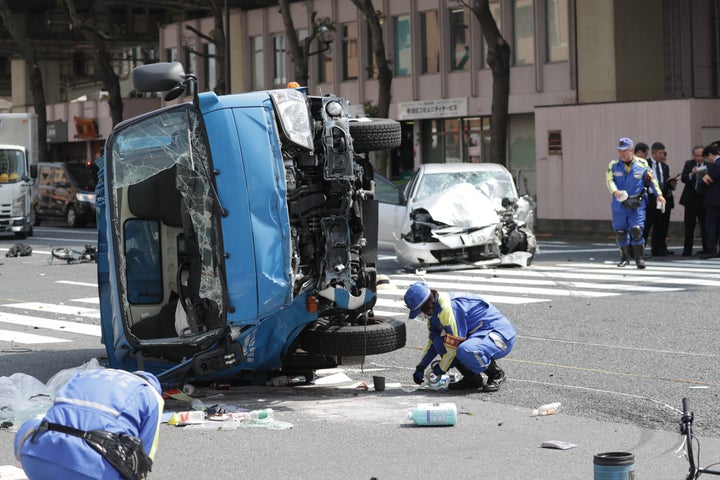 歩行者がはねられた事故現場で、乗用車（奥）が衝突し横転したごみ収集車＝4月19日、東京都豊島区