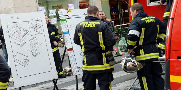 French firefighters gather at the site of a blast in central Paris on September 27, 2013. One person was killed, another was missing and at least three people were wounded in the blast that took place in the basement of a building. It is believed that the blast happened while workers were repairing a fuel tank. AFP PHOTO / PIERRE ANDRIEU (Photo credit should read PIERRE ANDRIEU/AFP/Getty Images)