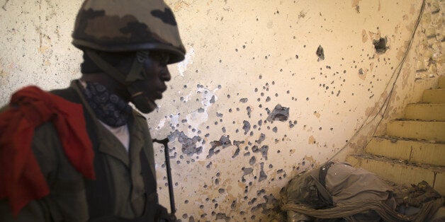 A Malian soldier discovers the body of an Islamist soldier in the Court in central Gao on February 22, 2013. Five people, including two suicide bombers, died Friday in car bombings in northern Mali, a day after fierce urban battles between French-led forces and Islamists left up to 20 extremists dead, officials said. France sent troops to Mali on January 11 to help the Malian army oust Islamist militants who last year captured the desert north of the country. AFP PHOTO /JOEL SAGET (Photo credit should read JOEL SAGET/AFP/Getty Images)