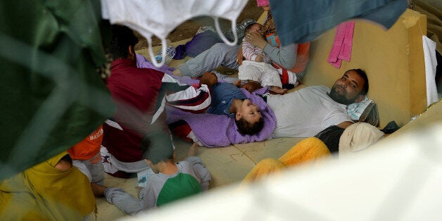 LAMPEDUSA, ITALY - OCTOBER 05: An immigrant mom breastfeeds her baby she and her family are detained after their arrival in the temporary shelter Center (CTP) on October 5, 2013 in Lampedusa, Italy. The search for bodies continues off the coast of Southern Italy as the death toll of African migrants who drowned as they tried to reach the island of Lampedusa is expected to reach over 300 people. The tragedy has bought fresh questions over the thousands of asylum seekers that arrive into Europe by boat each year. (Photo by Tullio M. Puglia/Getty Images)