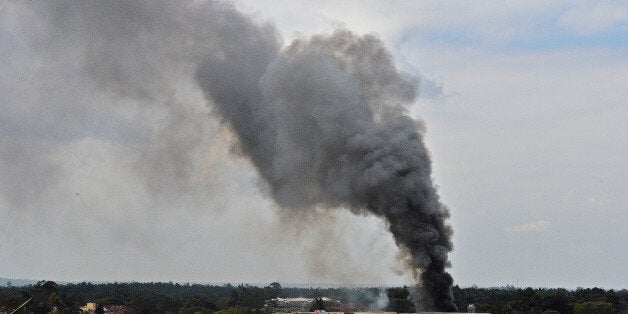 A column of smoke rises on September 23, 2013 from the beseiged Westgate shopping mall in Nairobi following a loud explosion. Kenyan security forces were locked in a fierce, final battle with Somali Islamist gunmen inside the upmarket mall on September 23 as huge explosions and a barrage of heavy gunfire echoed out of the complex. A thick cloud of black smoke billowed out from the Westgate mall as Kenyan officials said the 50-hour-long siege -- which has seen the gunmen massacre at least 62 people and take dozens more hostage -- was close to being resolved. Somalia's Al-Qaeda-linked Shebab insurgents have claimed the attack, which began midday on September 21, when the gunmen marched into the complex, firing grenades and automatic weapons and sending panicked shoppers fleeing. AFP PHOTO / CARL DE SOUZA (Photo credit should read CARL DE SOUZA/AFP/Getty Images)