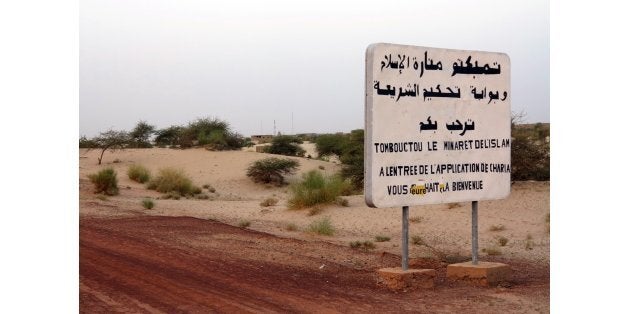 This picture on July 26, 2013 shows an old sign reading 'Timbuktu the minaret of islam, at the entrance of the sharia rule, welcomes you' at the entrance of the town. Millions of Malians are expected to vote Sunday in 'imperfect' elections they hope will usher in a new dawn of peace and stability in a country torn apart by an 18-month political crisis and armed conflict. Voters will have a choice of 27 candidates as they go to the polls for the first time since a separatist uprising led to a coup and then a sweeping Islamist offensive last year which upended one of the region's most stable democracies. AFP PHOTO / DOROTHEE THIENOT (Photo credit should read Dorothee Thienot/AFP/Getty Images)