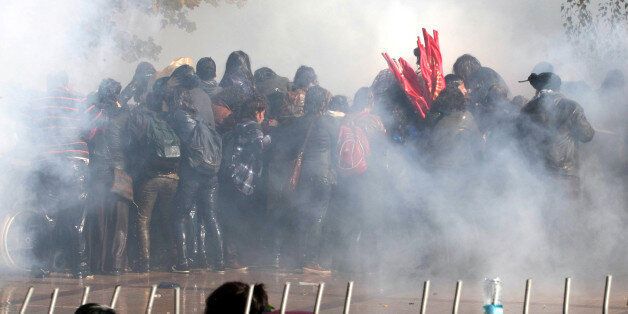 Turkish protesters run for cover as police fire water cannon and tear gas to disperse them on October 28, 2013 during a demonstration in Ankara against a court's refusal to detain a policeman accused of killing a demonstrator during the popular unrest in June. A police officer identified only as Ahmet S. is on trial accused of shooting to death 26-year-old Ethem Sarisuluk during mass anti-government street protests in Ankara in June. The Ankara court rejected a demand by the victim's lawyers that the defendant be detained and ruled instead that he could take part in hearings via video conference for security reasons. AFP PHOTO/ADEM ALTAN (Photo credit should read ADEM ALTAN/AFP/Getty Images)