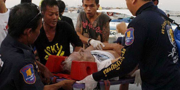 Thai rescue personnel evacuate an injured foreign tourist after a ferry sank off the coast in Pattaya on November 3, 2013. At least six passengers including three foreigners died after a tourist ferry sank off the Thai resort of Pattaya, police said. THAILAND OUT AFP PHOTO / STR (Photo credit should read STR/AFP/Getty Images)