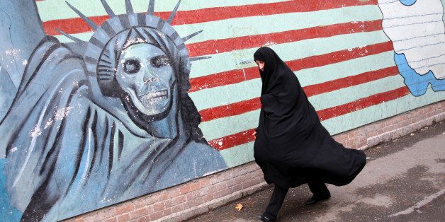 An Iranian woman walks past an anti-US mural painted on the wall of the former US embassy in Tehran on November 4, 2009 to mark the storming of the American embassy by Iranian students 30 years ago. Thousands of Iranians staged the noisy anti-US rally in central Tehran as riot police armed with batons and firing teargas moved in as several hundred opposition supporters attempted to stage an anti-government protest. AFP PHOTO/BEHROUZ MEHRI (Photo credit should read BEHROUZ MEHRI/AFP/Getty Images)