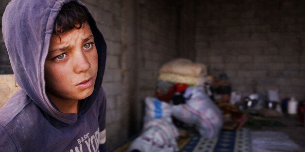 MAJDAL ANJAR, LEBANON - NOVEMBER 12: Bashar, an 11 year old Syrian refugee, stands near an empty garage he shares with member