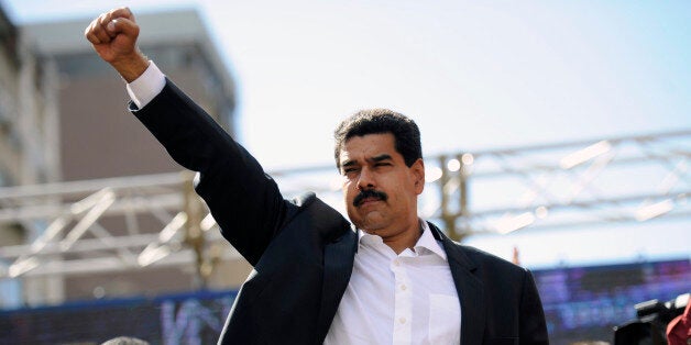 Venezuelan President Nicolas Maduro raises his fist during a rally in Caracas on November 12, 2013. Venezuela's ruling party eyed a vote Tuesday to pave the way for Maduro to govern by decree, broadening his powers, during an inflationary crisis a month before crucial municipal elections. AFP PHOTO/Leo RAMIREZ (Photo credit should read LEO RAMIREZ/AFP/Getty Images)