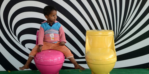A young Indian child plays on toilets during a 'Toilets are Beautiful' campaign on the occasion of World Toilet Day in New De
