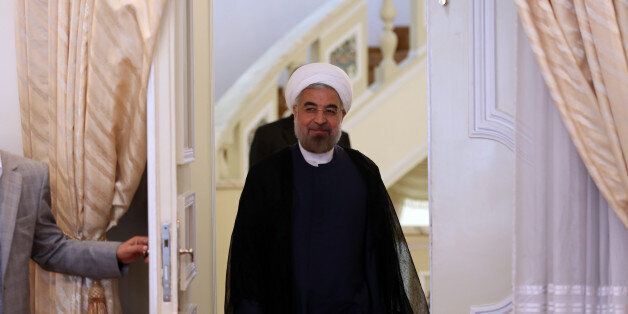 Iranian President Hassan Rouhani (C) arrives ahead of his meeting with International Peace envoy to Syria Lakhdar Brahimi in Tehran on October 27, 2013. AFP PHOTO/ATTA KENARE (Photo credit should read ATTA KENARE/AFP/Getty Images)