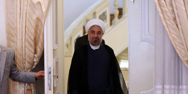 Iranian President Hassan Rouhani (C) arrives ahead of his meeting with International Peace envoy to Syria Lakhdar Brahimi in