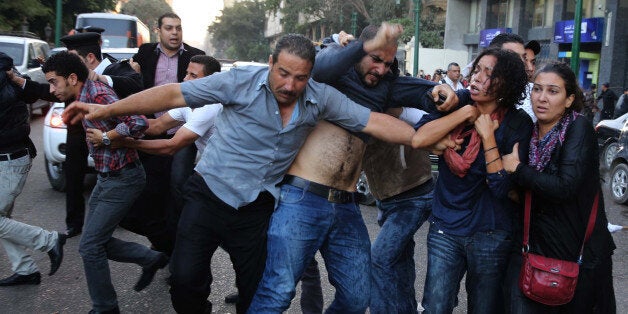 CAIRO, EGYPT - NOVEMBER 26 : Security forces disperse demonstrations protesting against the new law regulating street protests and Egypt's ongoing practice of trying civilians in military courts in front of the Shura council (the upper house of Egypt's parliament) on November 26, 2013 in Cairo, Egypt. Police used water cannons and teargas to disperse protesters outside the Shura Council. (Photo by Ahmed Ismail/Anadolu Agency/Getty Images)