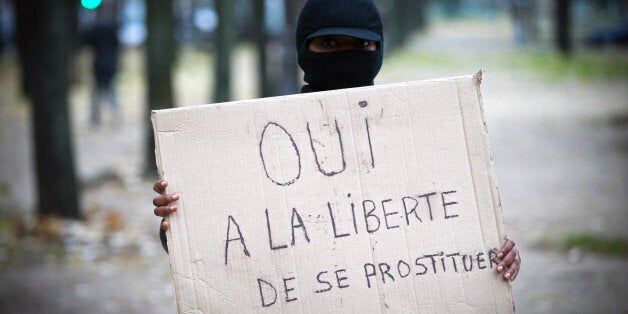 A demonstrator holds a placard reading 'yes to the freedom to prostitute oneself' on November 29, 2013 in Paris during a prot
