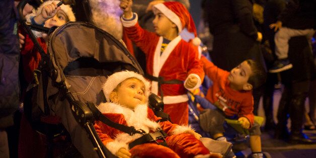 TEL AVIV, ISRAEL - DECEMBER 08: (ISRAEL OUT) Israeli Arab children are dressed as Santa Claus as locals prepare for Christmas on December 8, 2013 in Jaffa, a mixed Jewish-Arab suburb of Tel Aviv, Israel. Christianity is one of the recognized religions in Israel and is practiced by more than 150 thousand Israeli citizens (about 2.1% of population). Some 127 thousand (80% of Christian residents) of Israel are Arab Christians. (Photo by Uriel Sinai/Getty Images)