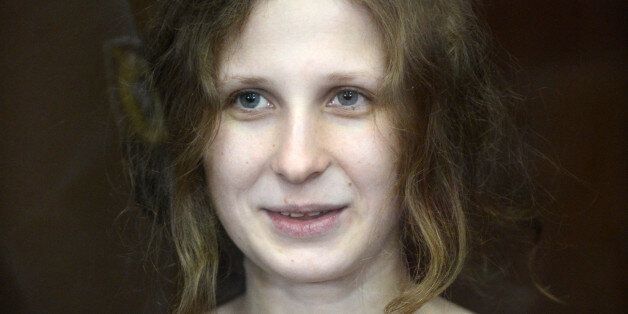 A file picture taken on August 17, 2012, shows one of the jailed members of the all-girl punk band 'Pussy Riot,' Maria Alyokhina, smiling as she sits in a glass-walled cage in a court in Moscow. A Russian court is to consider today Alyokhina's plea for early release from her two-year sentence for performing an anti-Putin stunt in a Moscow church last year. Alyokhina announced today she was going on hunger strike in protest over the authorities' failure to allow her to attend a parole hearing in person. AFP PHOTO / NATALIA KOLESNIKOVA (Photo credit should read NATALIA KOLESNIKOVA/AFP/Getty Images)